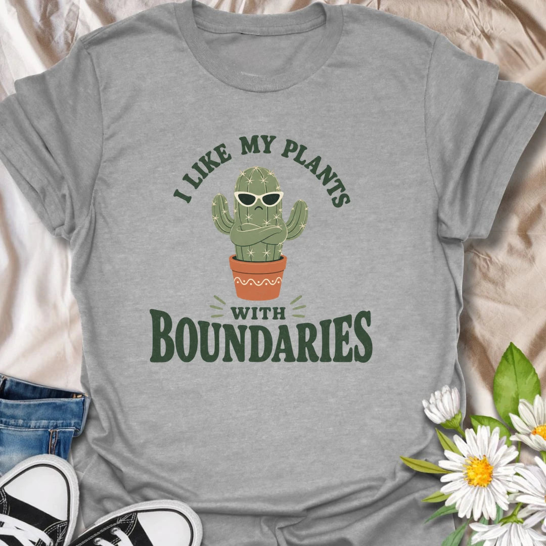 This I Like My Plants With Boundaries t-shirt is made for cactus lovers, succulent fans, and plant people with a sarcastic sense of humor. Featuring a grumpy potted cactus in sunglasses with crossed arms and bold retro lettering, this design has a funny low-maintenance plant vibe with plenty of attitude. Perfect for cactus lovers, plant moms, plant dads, succulent collectors, introverts, and anyone who appreciates plants with strong personal boundaries.