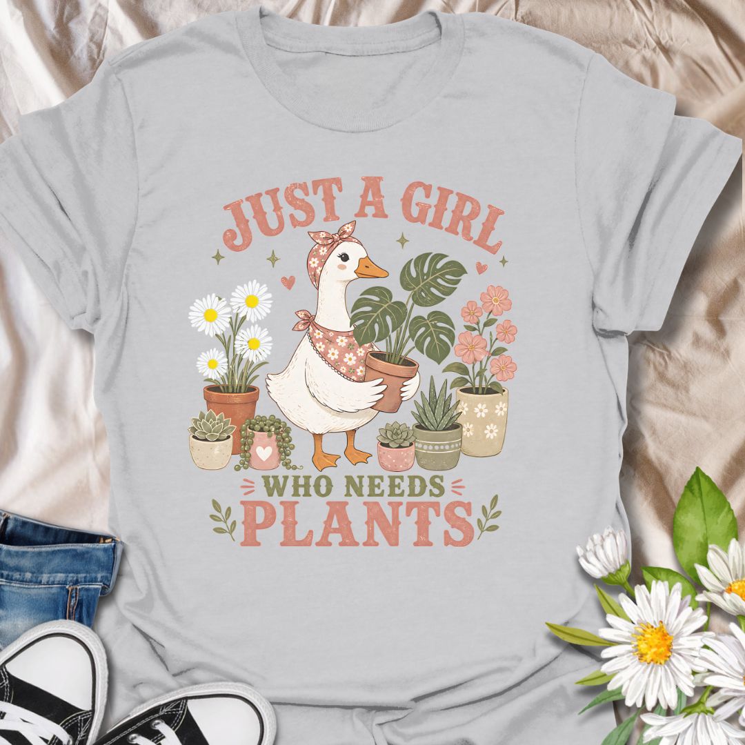 This Just A Girl Who Needs Plants t-shirt is made for plant lovers who know leafy friends, flowers, and a little garden time can fix almost anything. Featuring a sweet goose holding a potted monstera, surrounded by daisies, succulents, flowering plants, hearts, and soft botanical details, this design has a cute cottagecore-inspired feel. Perfect for plant moms, gardeners, houseplant collectors, flower fans, and anyone who proudly needs more plants in their life.