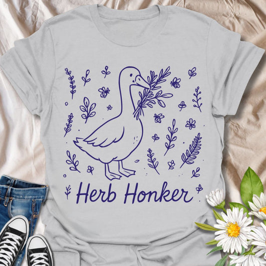 Funny ‘Herb Honker’ goose shirt featuring a happy goose carrying herbs. Great for gardeners, cooks, herbalists, and fans of quirky farm animal designs.