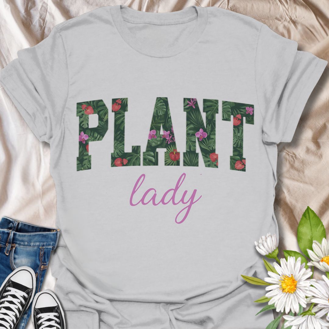 Show off your green thumb in style with this vibrant “Plant Lady” graphic t-shirt featuring bold botanical lettering and a feminine touch. Perfect for plant moms, garden lovers, and anyone who proudly embraces their love for all things leafy and green.