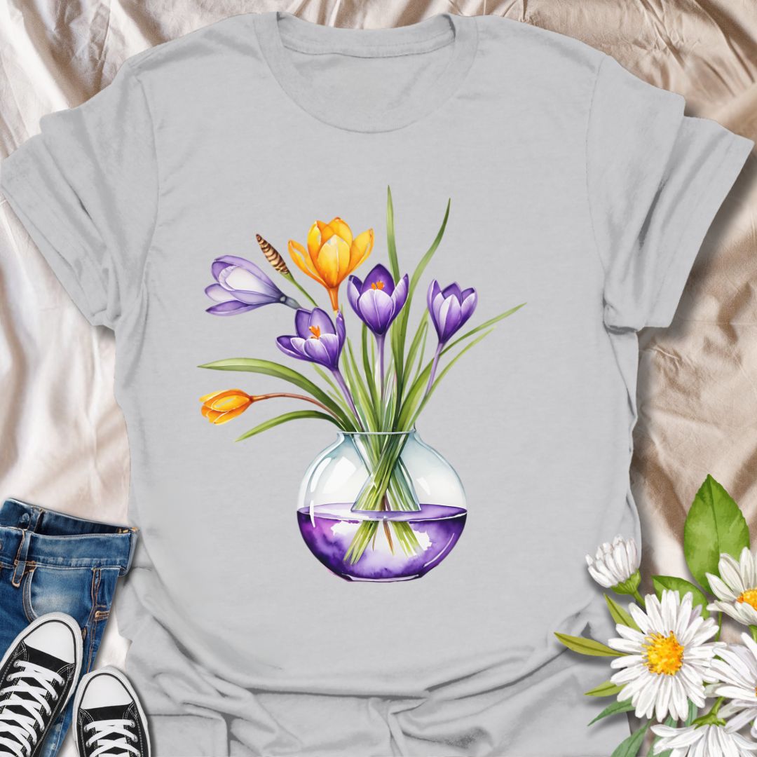 Brighten your wardrobe with this beautiful watercolor floral t-shirt featuring a bouquet of vibrant tulips in a glass vase. Printed on a soft yellow tee, this design is perfect for flower lovers, garden enthusiasts, or anyone who loves cheerful botanical art. Ideal as a spring outfit or a thoughtful gift for plant moms and nature admirers.