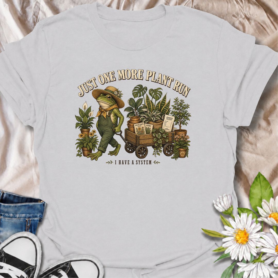 A funny plant-shopping T-shirt featuring a stylish frog and a wagon full of nursery finds. Made for plant lovers who can never buy just one more.