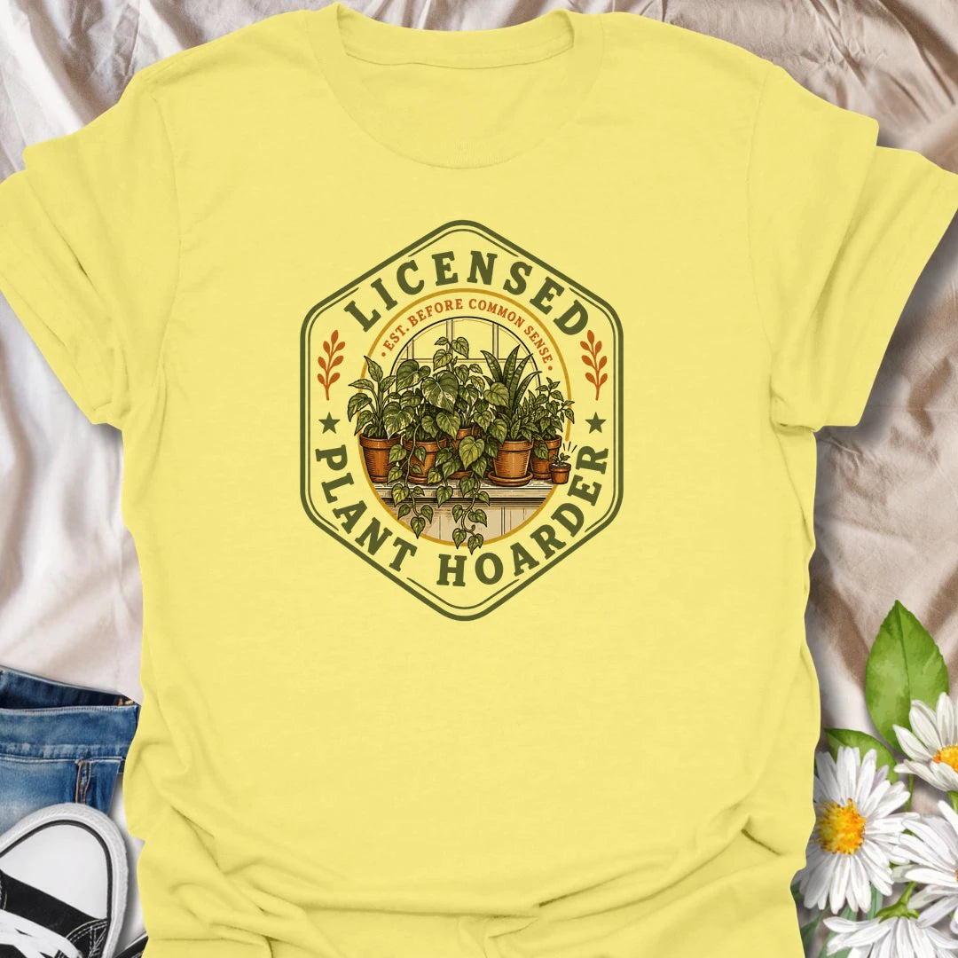 This Licensed Plant Hoarder t-shirt is made for houseplant lovers who ran out of space long before they ran out of excuses. Featuring a vintage badge-style design with an overcrowded windowsill full of potted plants, trailing vines, and the phrase Est. Before Common Sense, this tee has a funny plant-collector feel with classic botanical charm. Perfect for plant moms, plant dads, indoor gardeners, houseplant collectors, propagation fans, and anyone proudly licensed to bring home just one more plant.