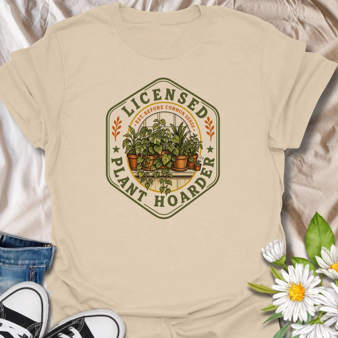 This Licensed Plant Hoarder t-shirt is made for houseplant lovers who ran out of space long before they ran out of excuses. Featuring a vintage badge-style design with an overcrowded windowsill full of potted plants, trailing vines, and the phrase Est. Before Common Sense, this tee has a funny plant-collector feel with classic botanical charm. Perfect for plant moms, plant dads, indoor gardeners, houseplant collectors, propagation fans, and anyone proudly licensed to bring home just one more plant.