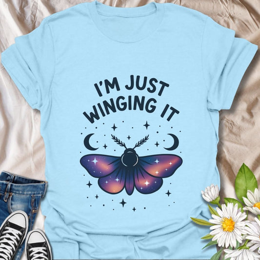 Embrace spontaneity with this “I'm Just Winging It” t-shirt featuring a magical butterfly, crescent moons, and starry night vibes. Perfect for free spirits, nature lovers, and celestial style fans.