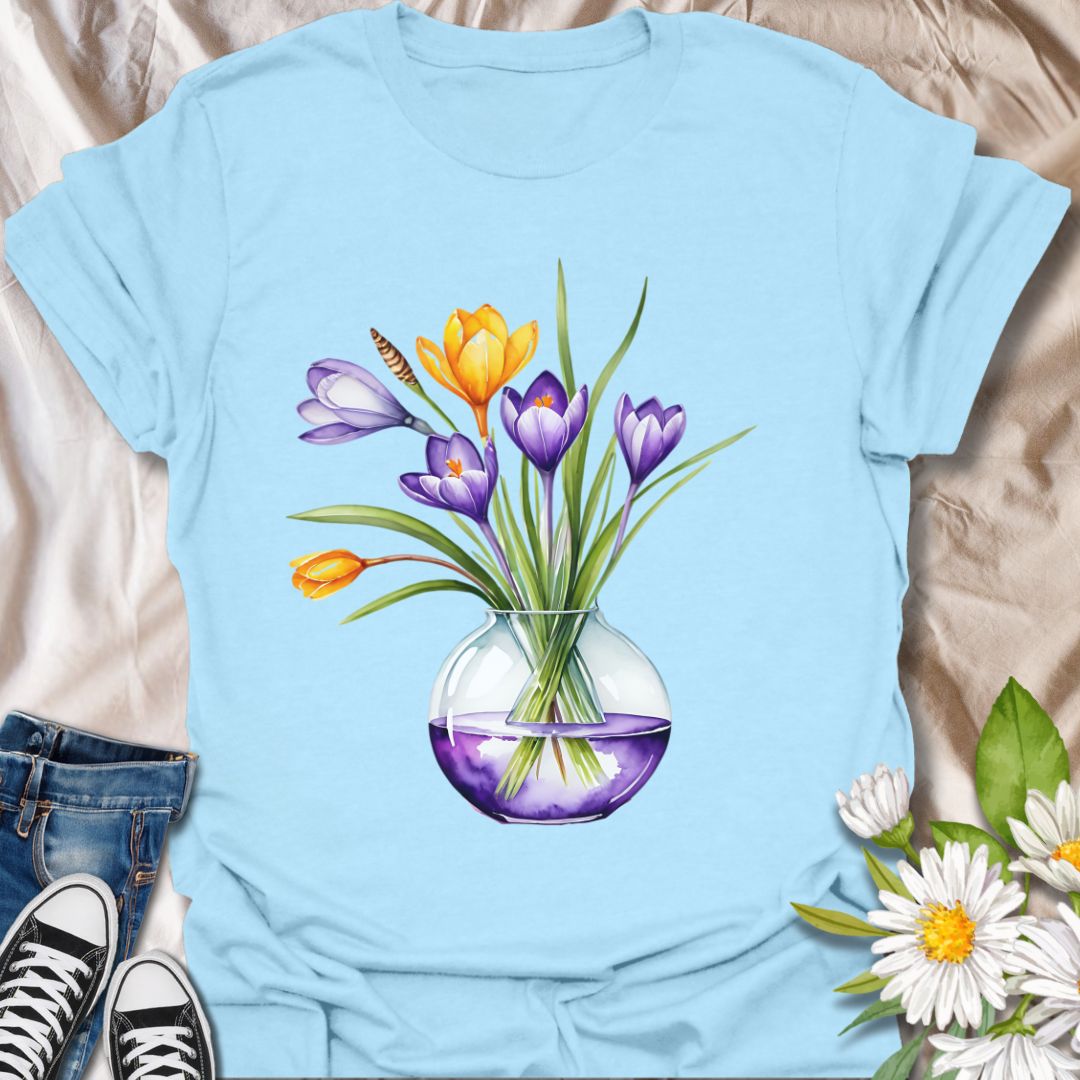 Brighten your wardrobe with this beautiful watercolor floral t-shirt featuring a bouquet of vibrant tulips in a glass vase. Printed on a soft yellow tee, this design is perfect for flower lovers, garden enthusiasts, or anyone who loves cheerful botanical art. Ideal as a spring outfit or a thoughtful gift for plant moms and nature admirers.