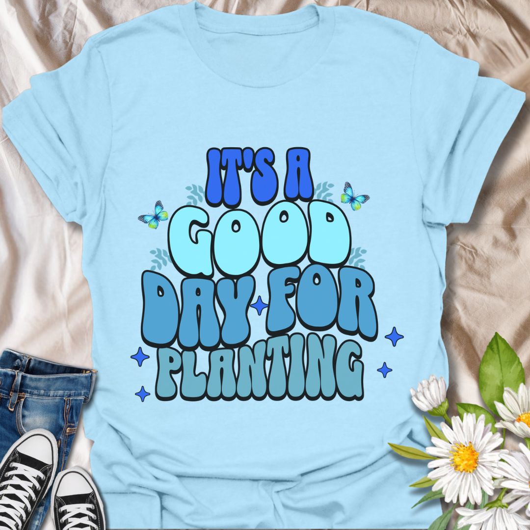 Bright and cheerful "It's a Good Day for Planting" t-shirt featuring retro-style typography with playful butterflies and vibrant blue tones. Perfect for gardeners, plant lovers, and anyone who finds joy in planting flowers and tending to nature. This planting t-shirt is an Ideal gardening gift, outdoor hobby shirt, botanical fashion, nature lover apparel, and springtime outfit.  
