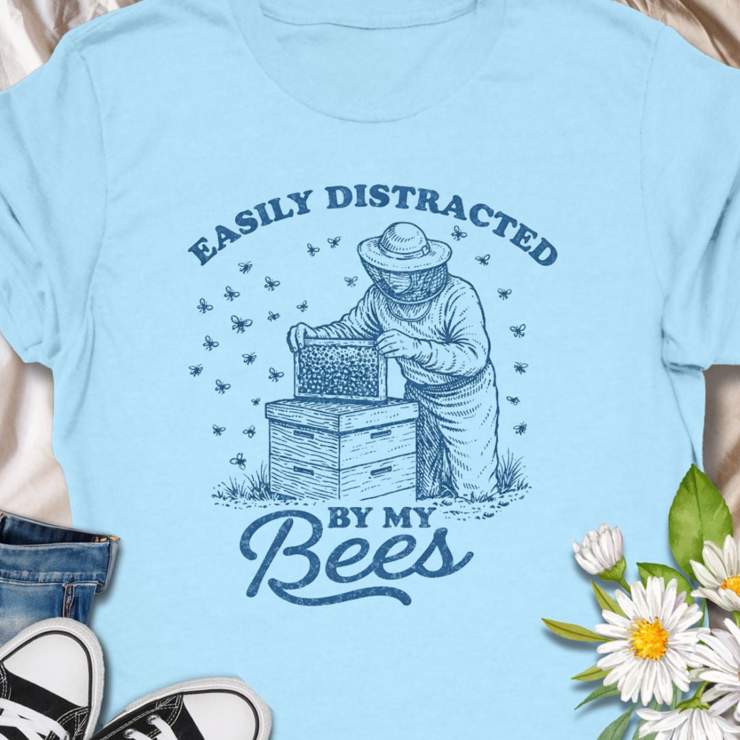 Show off your hive obsession with this “Easily Distracted By My Bees” t-shirt, featuring a vintage-style beekeeper and buzzing bees. Perfect gift for apiarists, backyard beekeepers, and bee lovers who’d rather be checking their hives than anything else.