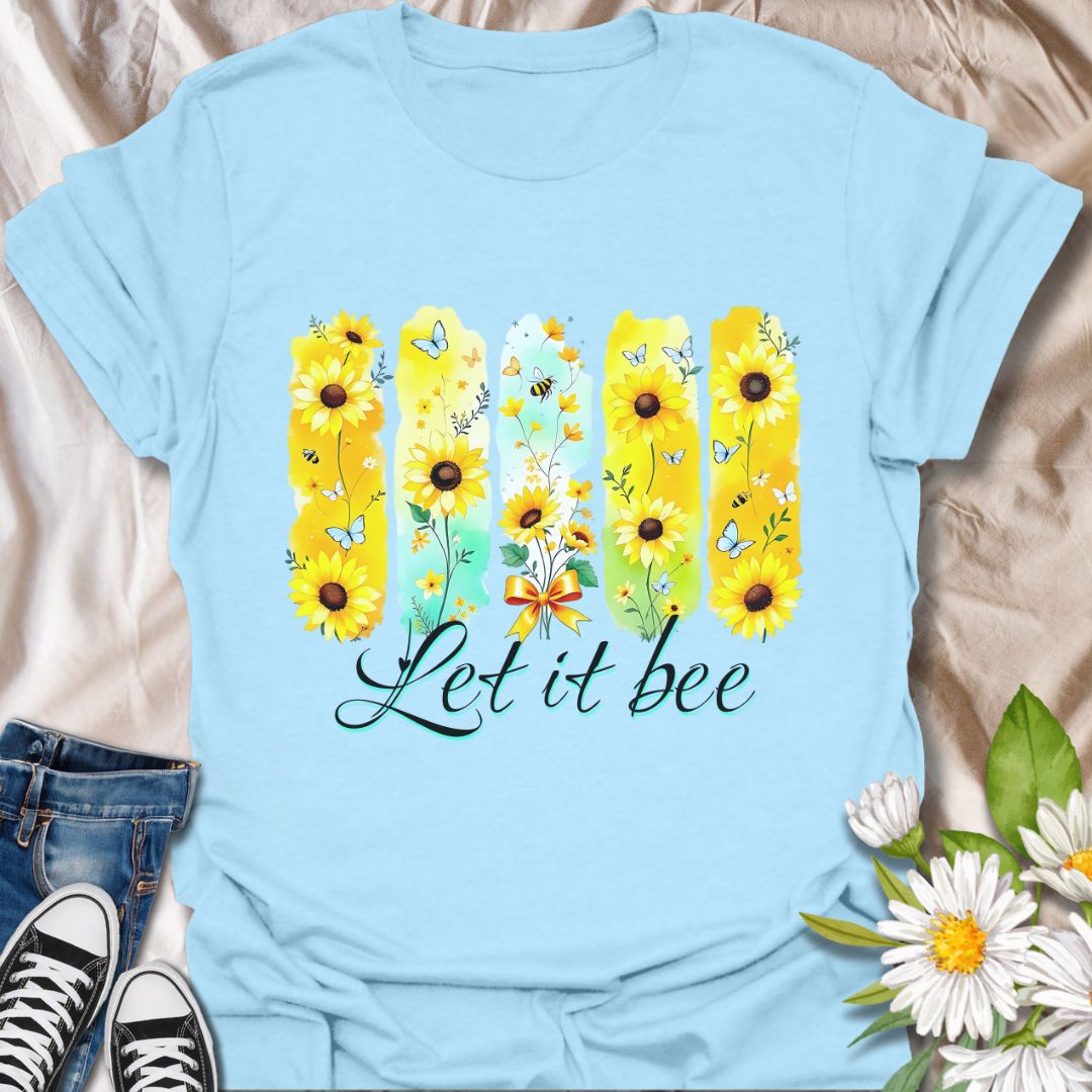 Bright sunflower t-shirt with bees and butterflies and the playful phrase "Let it bee." Perfect for nature lovers, bee enthusiasts, gardeners, and wildflower fans who appreciate pollinators. Fun spring and summer tee celebrating positivity and nature’s beauty. Light Blue