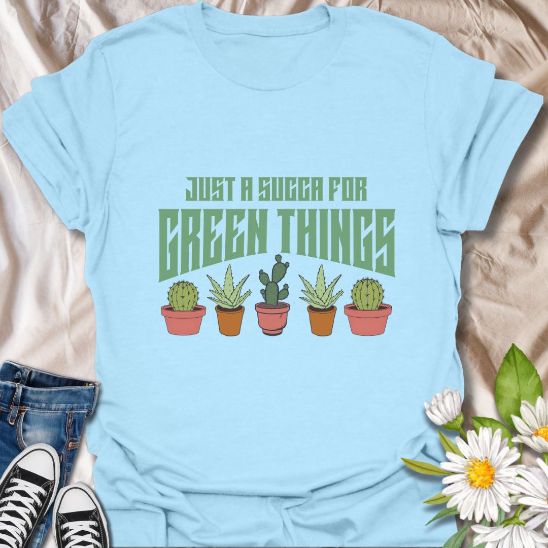 Embrace your love for all things leafy with this playful “Just a Succa for Green Things” t-shirt. Featuring a lineup of adorable potted succulents and bold retro typography, it’s perfect for plant lovers with a sense of humor.