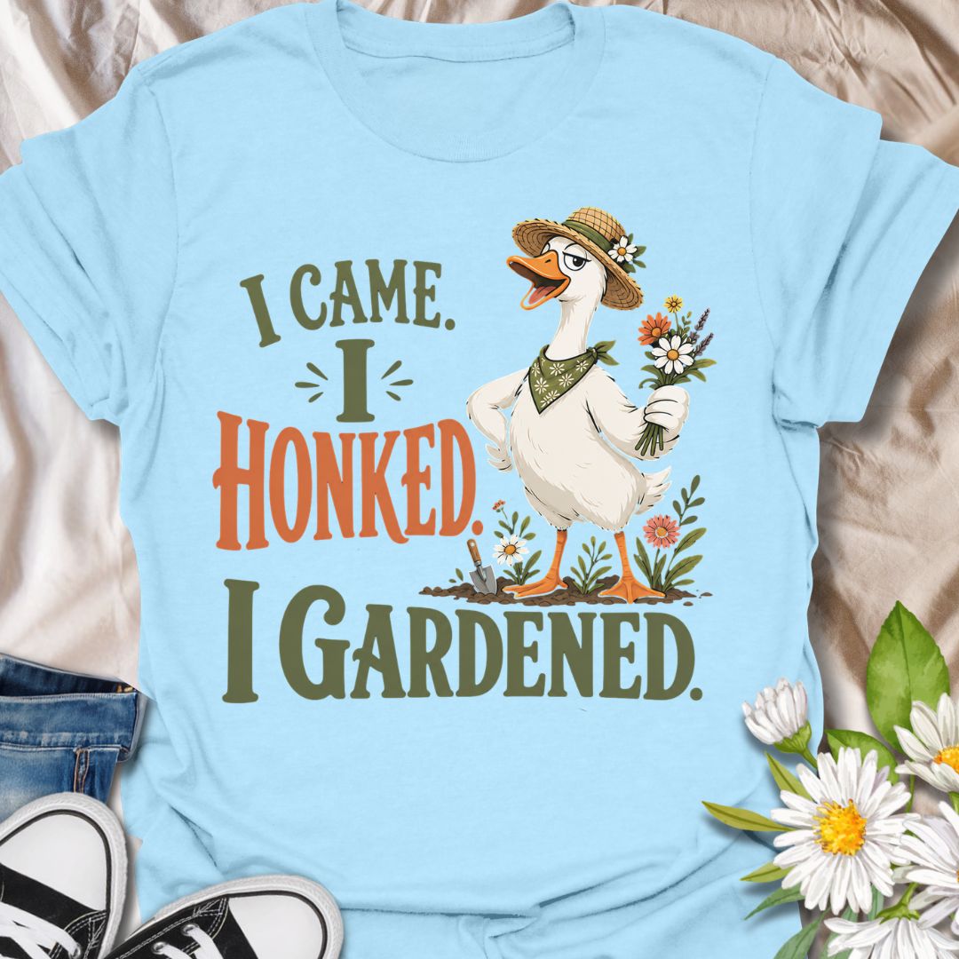 This I Came I Honked I Gardened t-shirt is made for gardeners who like their plant humor with a little chaotic goose energy. Featuring a confident garden goose in a straw hat holding flowers, surrounded by blooms, a trowel, soil, and bold vintage-style lettering, this design has a funny cottagecore garden feel. Perfect for gardeners, plant lovers, flower fans, goose lovers, backyard growers, and anyone who enjoys a playful botanical design with attitude.