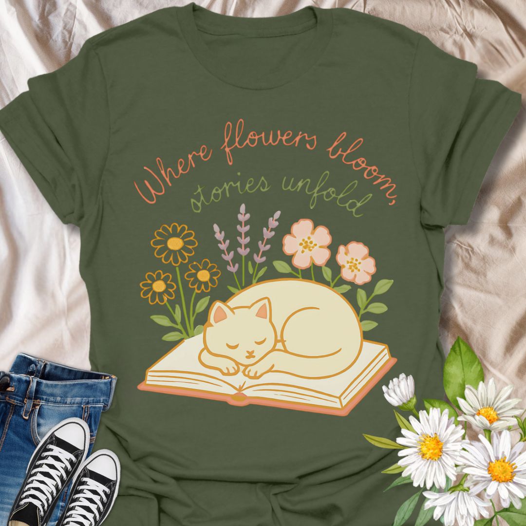 Cozy cat and book t-shirt with pastel flowers and the quote 'Where flowers bloom, stories unfold.' Perfect for book lovers, cat moms, gardeners, and daydreamers who adore cottagecore and literary aesthetics. Soft and sweet tee ideal for spring, reading nooks, and gifting.