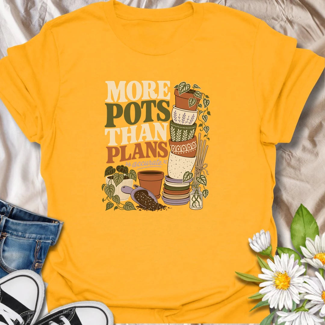 A relatable plant lover T-shirt for anyone whose pot collection has grown faster than their planting plans. The design features a tall stack of decorative pots, trailing houseplants, propagation cuttings, and potting soil. A fun gift for gardeners, plant collectors, and anyone who can never resist another beautiful planter.