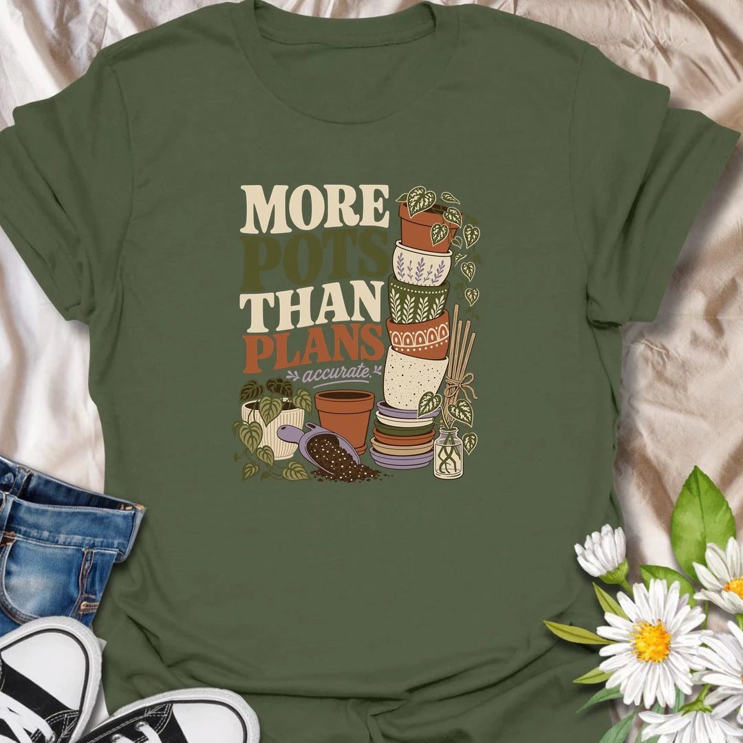 A relatable plant lover T-shirt for anyone whose pot collection has grown faster than their planting plans. The design features a tall stack of decorative pots, trailing houseplants, propagation cuttings, and potting soil. A fun gift for gardeners, plant collectors, and anyone who can never resist another beautiful planter.