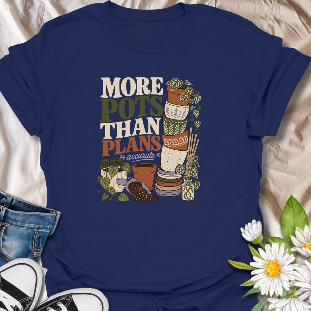 A relatable plant lover T-shirt for anyone whose pot collection has grown faster than their planting plans. The design features a tall stack of decorative pots, trailing houseplants, propagation cuttings, and potting soil. A fun gift for gardeners, plant collectors, and anyone who can never resist another beautiful planter.
