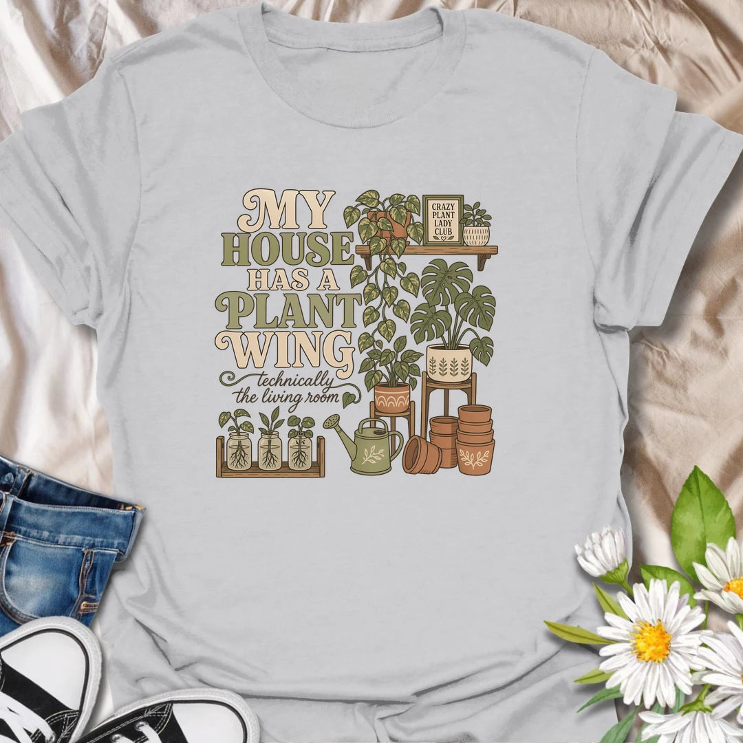A funny houseplant T-shirt for anyone whose living room has gradually become a dedicated indoor garden. The design features overflowing plant shelves, propagation jars, watering supplies, and stacks of terracotta pots. A charming gift for indoor gardeners, plant moms, and collectors with greenery in every room.