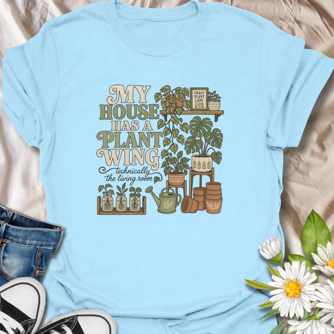 A funny houseplant T-shirt for anyone whose living room has gradually become a dedicated indoor garden. The design features overflowing plant shelves, propagation jars, watering supplies, and stacks of terracotta pots. A charming gift for indoor gardeners, plant moms, and collectors with greenery in every room.