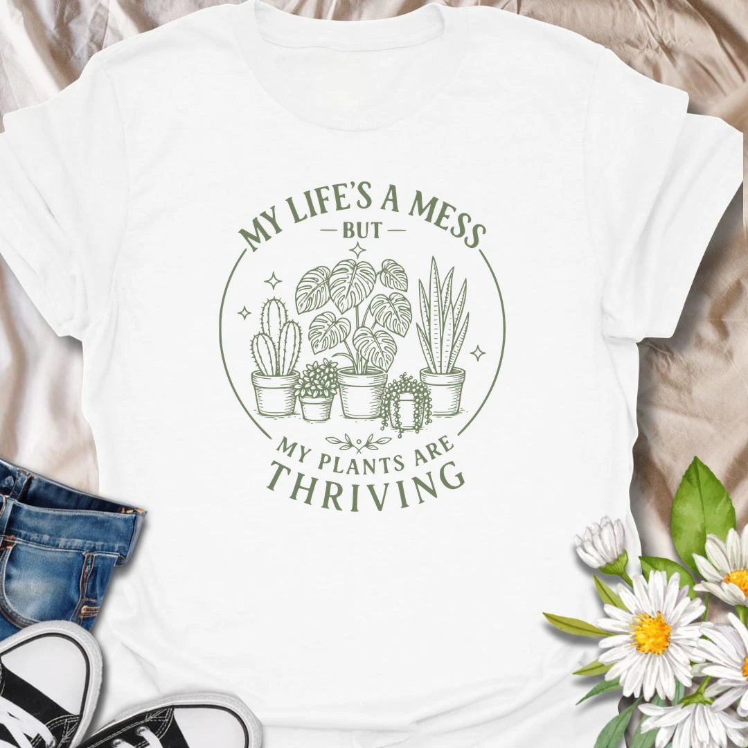 Plants Are Thriving t-shirt for anyone whose life may be messy, but whose houseplants are somehow doing beautifully.
The simple botanical line-art design gives the shirt a clean, relaxed look with relatable plant lover humor.
It is perfect for plant moms, indoor gardeners, houseplant collectors, and anyone who measures success by healthy leaves.
A funny gift for plant people who may not have everything together, but definitely have thriving plants.