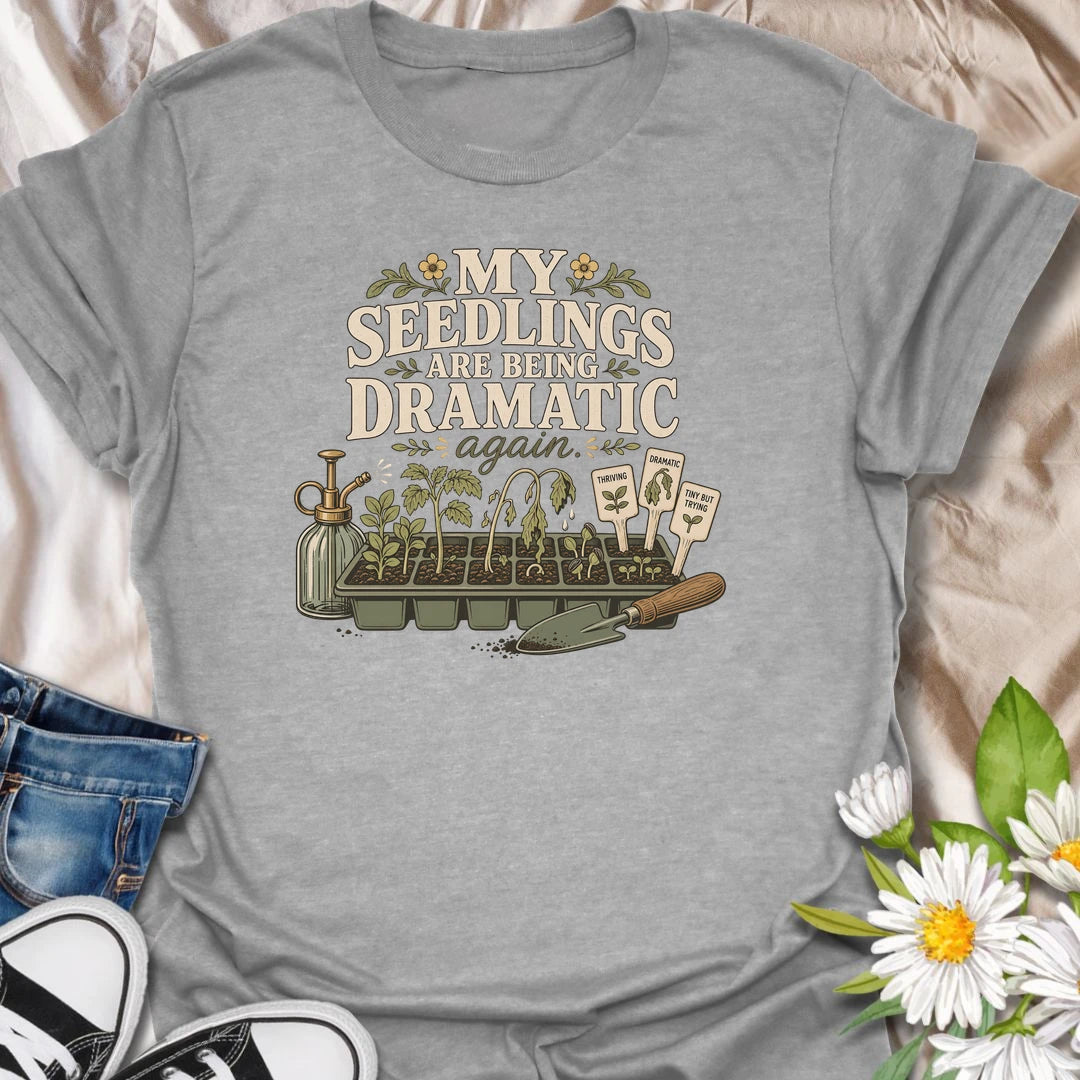 Seed-starting season comes with plenty of drama, and this funny gardening T-shirt understands. Featuring the phrase “My Seedlings Are Being Dramatic Again,” it includes wilted sprouts, plant markers, a mister, and a hand trowel. A perfect gift for vegetable gardeners and seed-starting enthusiasts.