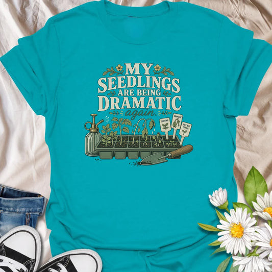 Seed-starting season comes with plenty of drama, and this funny gardening T-shirt understands. Featuring the phrase “My Seedlings Are Being Dramatic Again,” it includes wilted sprouts, plant markers, a mister, and a hand trowel. A perfect gift for vegetable gardeners and seed-starting enthusiasts.