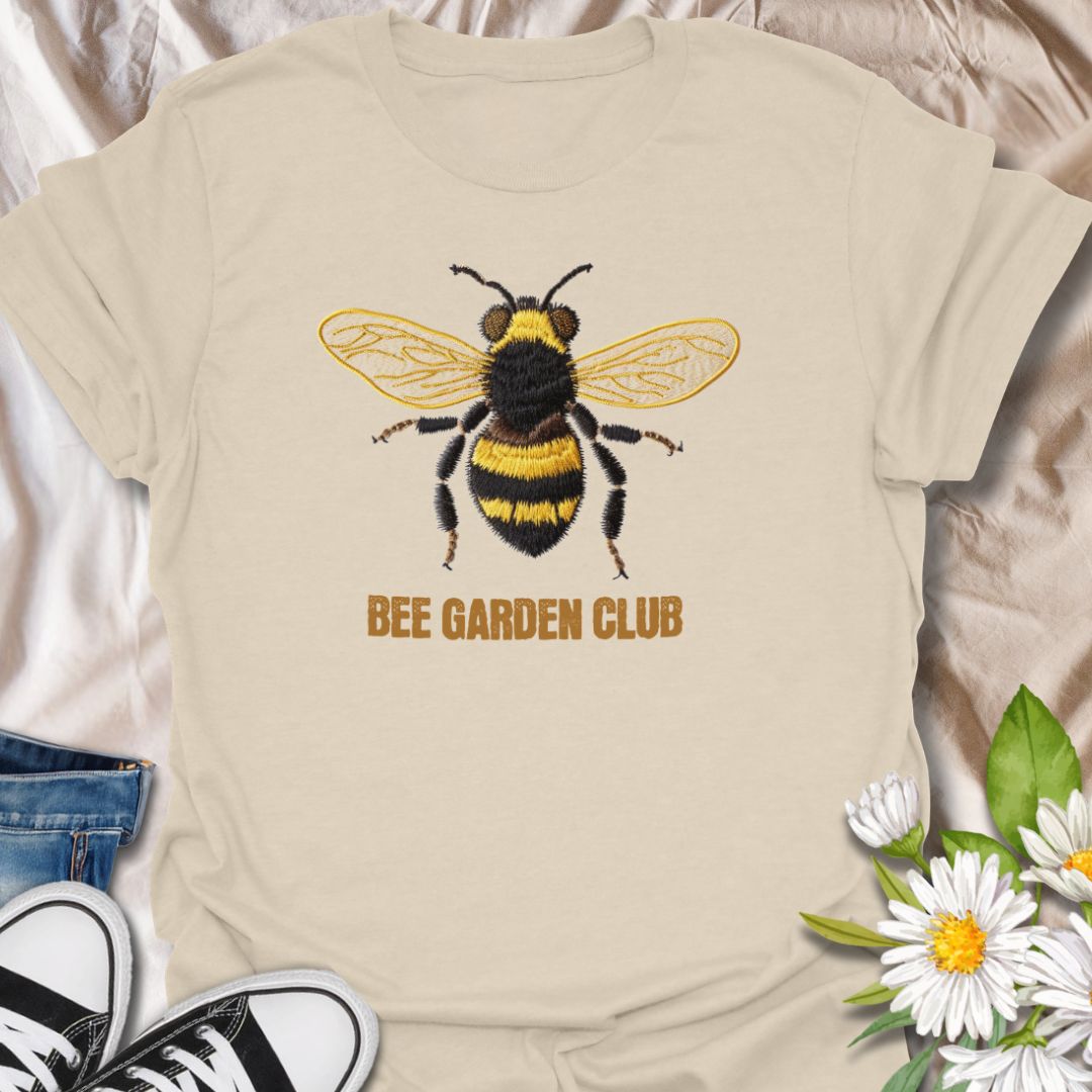 This Bee Garden Club t-shirt is made for gardeners, pollinator lovers, and nature fans who want a simple bee design with a refined botanical feel. Featuring a detailed faux-embroidered bee with golden wings, fuzzy black and yellow stripes, and clean Bee Garden Club lettering, this design has a classic garden-club look that is easy to wear. Perfect for bee lovers, gardeners, wildflower fans, pollinator supporters, nature lovers, and anyone who wants to celebrate the garden’s hardest little workers.