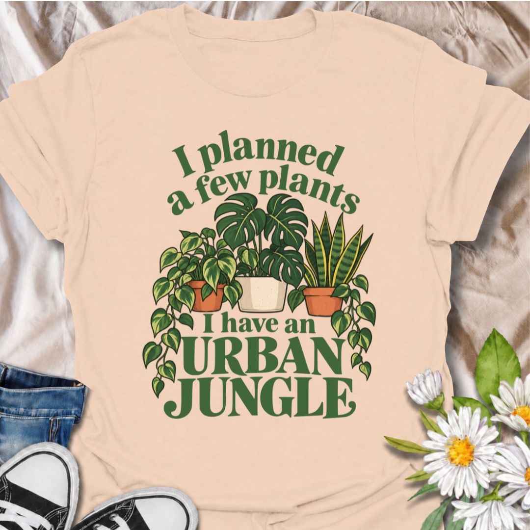 A funny plant T-shirt for anyone who started with a few houseplants and somehow ended up living in an indoor jungle. The phrase “I Planned a Few Plants. I Have an Urban Jungle.” captures the familiar reality of plant collecting with light, relatable humor. Featuring monstera, pothos, and snake plants, this design is perfect for plant parents, houseplant collectors, and indoor gardeners. It makes a great gift for anyone whose shelves, windowsills, and corners have slowly disappeared behind greenery. Perfect 