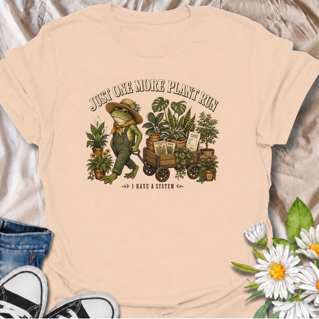 A funny plant-shopping T-shirt featuring a stylish frog and a wagon full of nursery finds. Made for plant lovers who can never buy just one more.