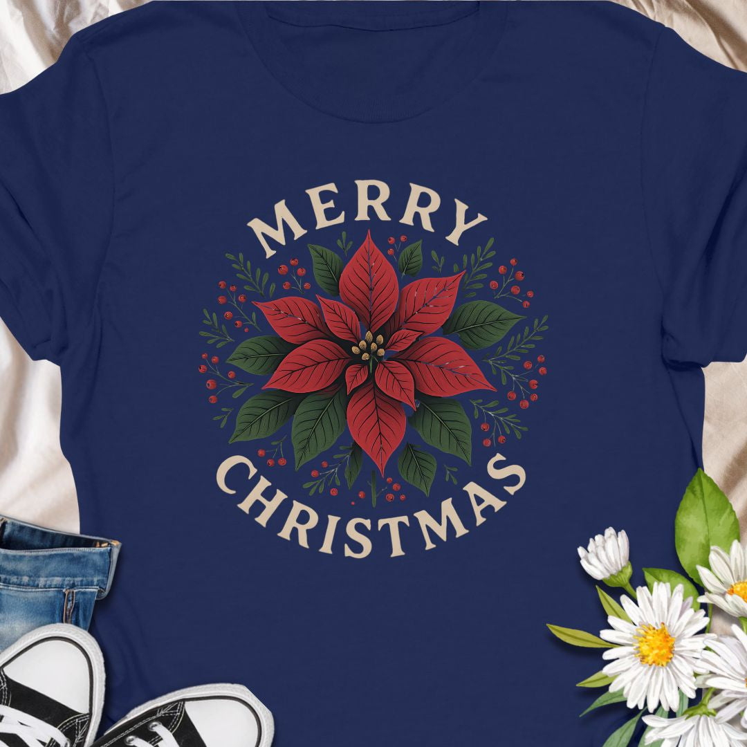 Botanical tee that carries a quietly festive spirit — a poinsettia framed by warm "Merry Christmas" lettering.  Subtle vintage tones in the print give the design a homey, handmade feel that blends with cozy kitchens, neighborhood caroling, and quiet evenings by twinkling lights. Wear it while wrapping gifts, making cocoa, or hosting a laid-back family dinner