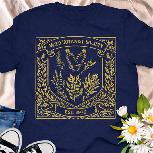 Join the Wild Botanist Society with this vintage-inspired botanical t-shirt. Designed for plant lovers, gardeners, and nature enthusiasts who love earthy, heritage style. A perfect everyday tee for plant parents, garden lovers, and botanical souls.