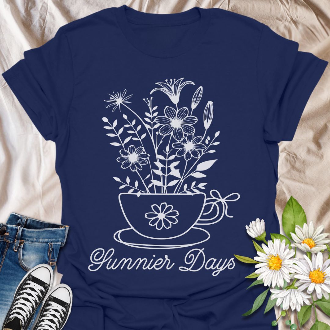 Charming floral t-shirt featuring hand-drawn white flowers blooming from a teacup with the words “Sunnier Days.” A cozy, uplifting design for flower lovers, tea drinkers, and anyone who embraces the simple joys of life. Great gift for gardeners and sunny souls.