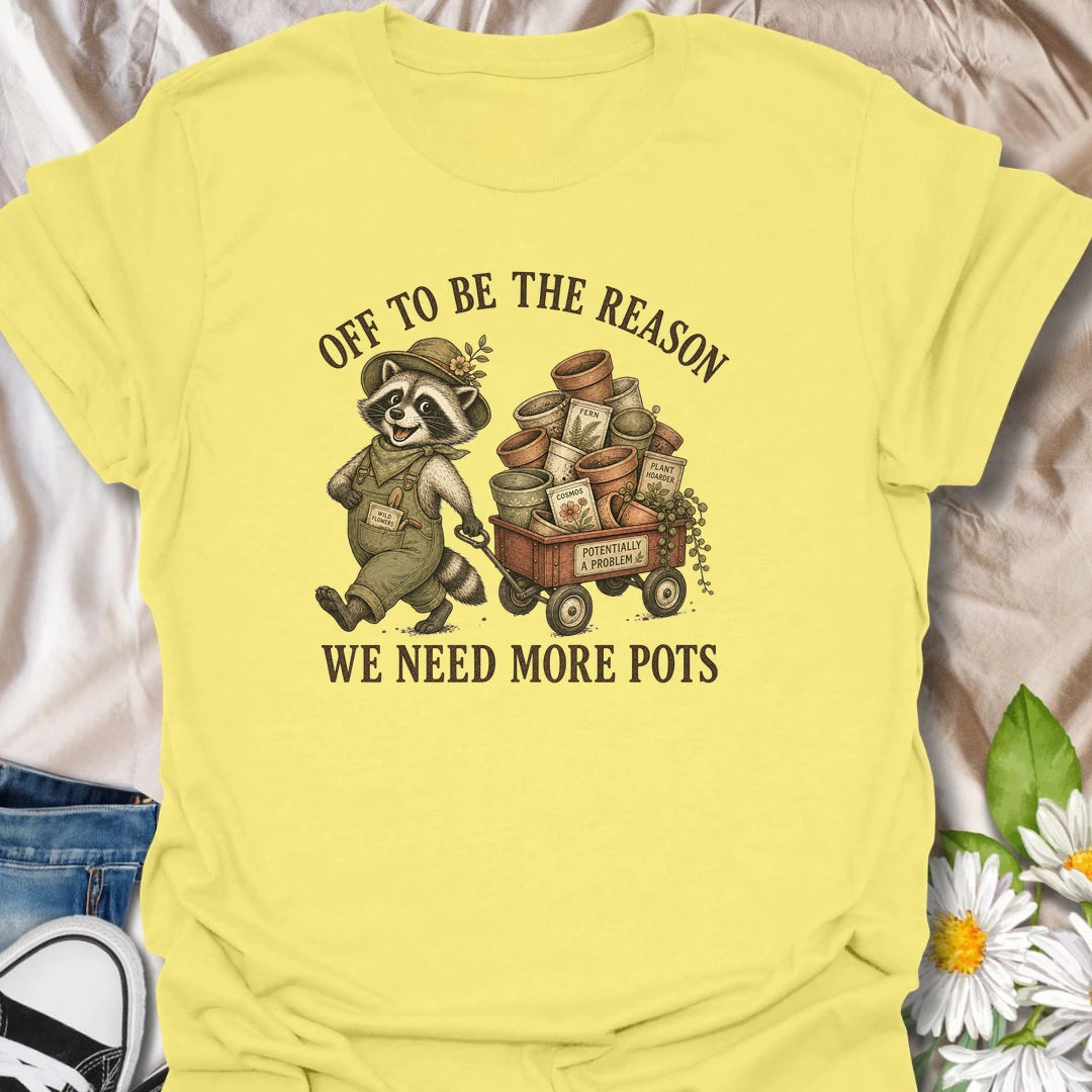 This Off To Be The Reason We Need More Pots t-shirt is perfect for gardeners and plant lovers who always have another plant, cutting, or seedling waiting for a home. Featuring a cheerful raccoon with a wagon full of flower pots, seed packets, and garden supplies, this funny botanical design is great for plant moms, houseplant collectors, gardeners, and anyone who can never have too many pots.