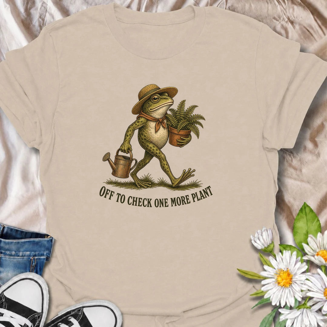 A funny plant T-shirt for anyone who can never resist checking on just one more plant. Featuring a charming vintage-style frog carrying a fern and watering can, this design is perfect for plant parents, gardeners, and nursery regulars. The phrase “Off to Check One More Plant” captures the familiar habit of turning a quick plant check into a much longer wander. It makes a great gift for houseplant lovers, garden enthusiasts, frog lovers, and anyone whose plants get more attention than most people. Ideal for 