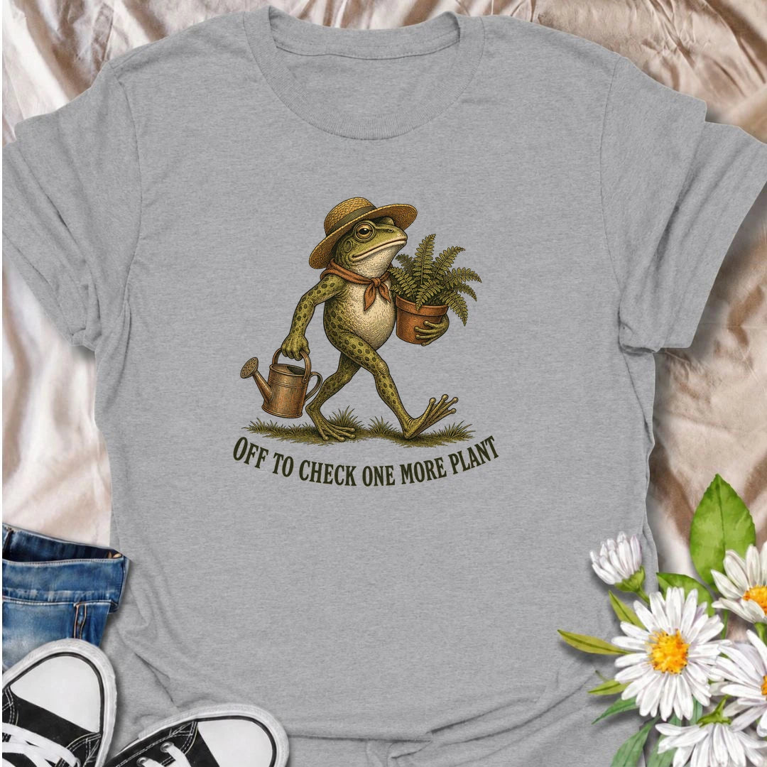 A funny plant T-shirt for anyone who can never resist checking on just one more plant. Featuring a charming vintage-style frog carrying a fern and watering can, this design is perfect for plant parents, gardeners, and nursery regulars. The phrase “Off to Check One More Plant” captures the familiar habit of turning a quick plant check into a much longer wander. It makes a great gift for houseplant lovers, garden enthusiasts, frog lovers, and anyone whose plants get more attention than most people. Ideal for 
