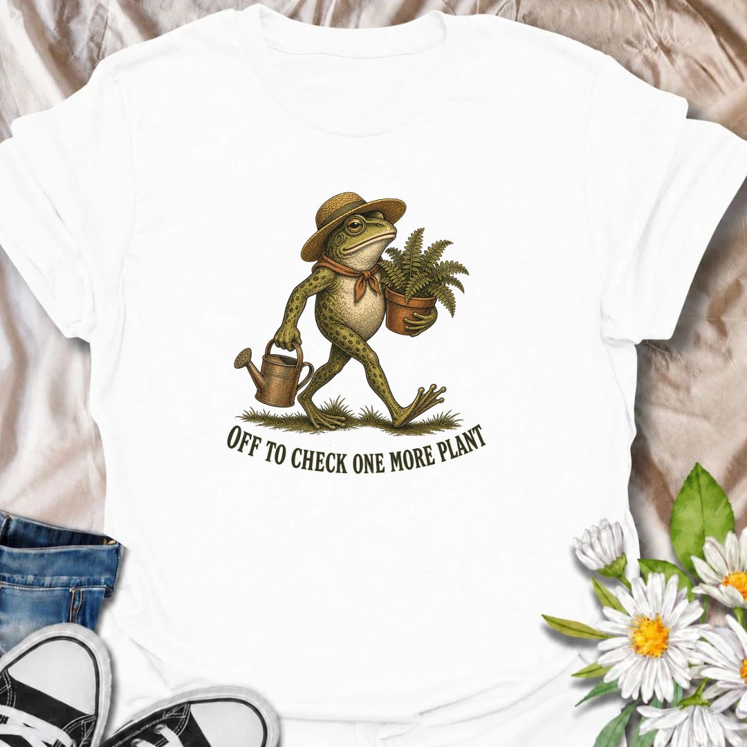 A funny plant T-shirt for anyone who can never resist checking on just one more plant. Featuring a charming vintage-style frog carrying a fern and watering can, this design is perfect for plant parents, gardeners, and nursery regulars. The phrase “Off to Check One More Plant” captures the familiar habit of turning a quick plant check into a much longer wander. It makes a great gift for houseplant lovers, garden enthusiasts, frog lovers, and anyone whose plants get more attention than most people. Ideal for 