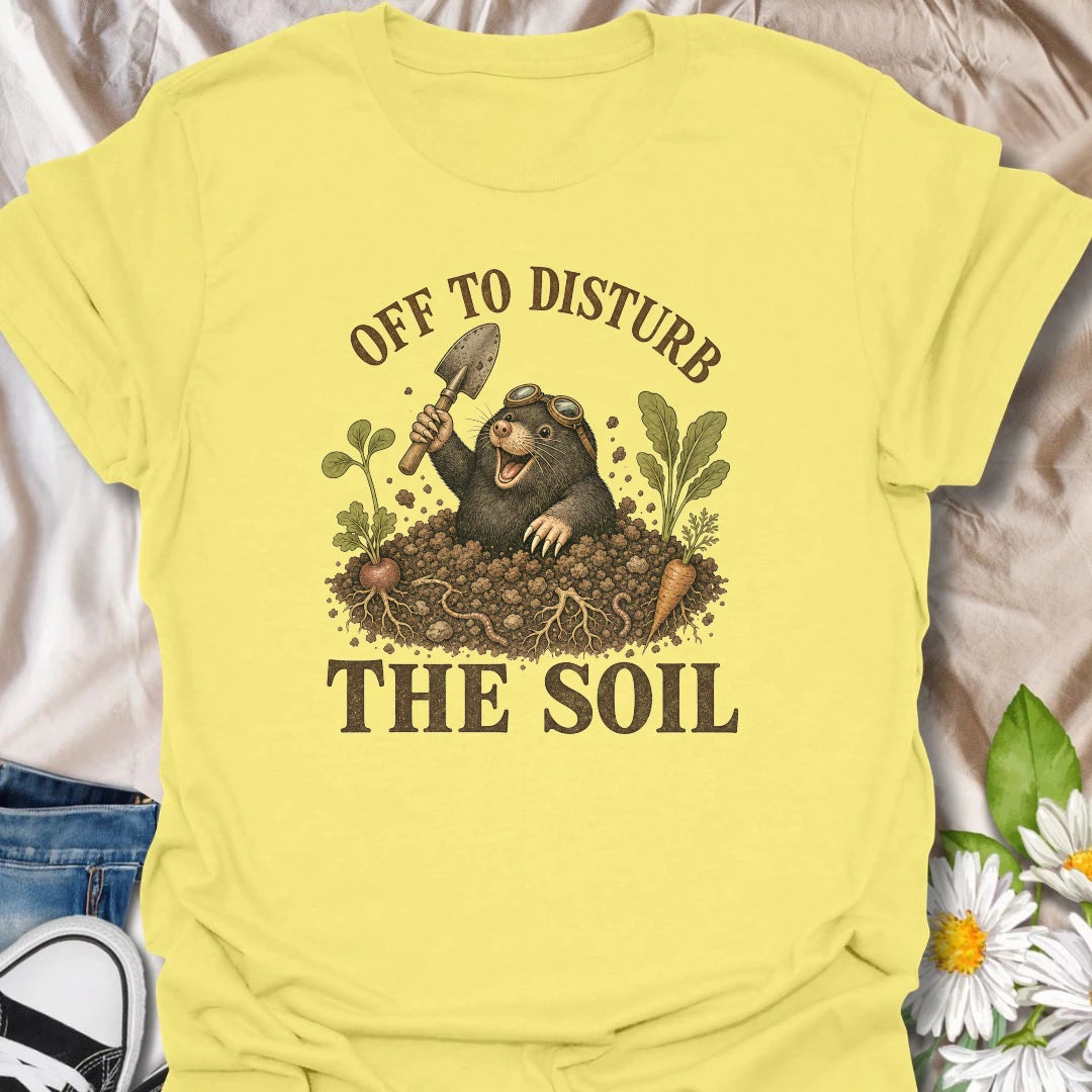 This Off To Disturb The Soil t-shirt is perfect for gardeners who love digging, planting, and making a little mess in the dirt. Featuring a happy mole popping out of the soil with a garden trowel, vegetables, roots, and earthy details, this funny gardening design is great for backyard growers, vegetable gardeners, plant lovers, and anyone who enjoys getting their hands dirty.