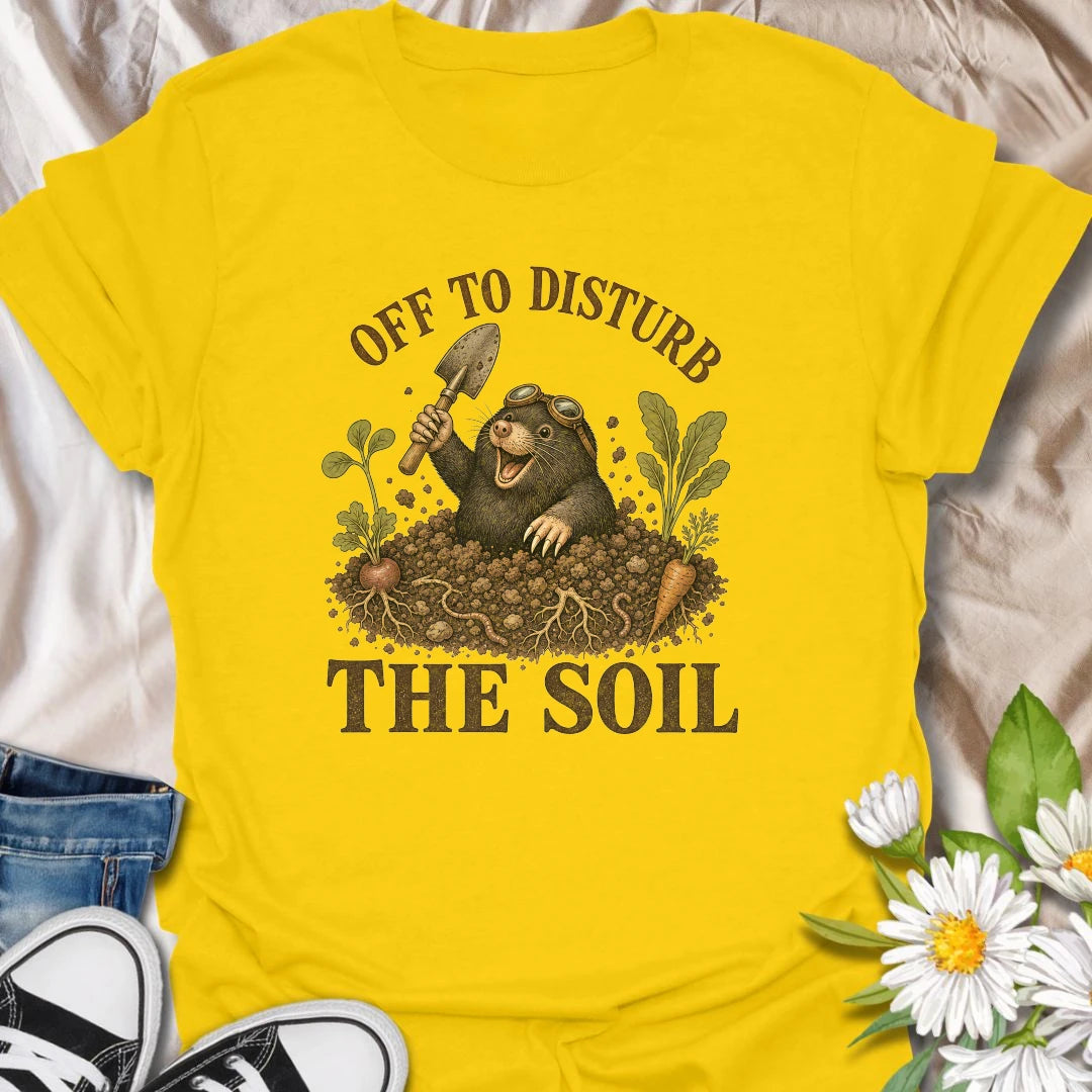 This Off To Disturb The Soil t-shirt is perfect for gardeners who love digging, planting, and making a little mess in the dirt. Featuring a happy mole popping out of the soil with a garden trowel, vegetables, roots, and earthy details, this funny gardening design is great for backyard growers, vegetable gardeners, plant lovers, and anyone who enjoys getting their hands dirty.