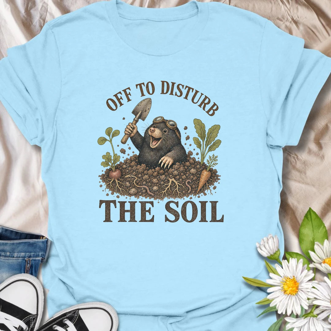 This Off To Disturb The Soil t-shirt is perfect for gardeners who love digging, planting, and making a little mess in the dirt. Featuring a happy mole popping out of the soil with a garden trowel, vegetables, roots, and earthy details, this funny gardening design is great for backyard growers, vegetable gardeners, plant lovers, and anyone who enjoys getting their hands dirty.