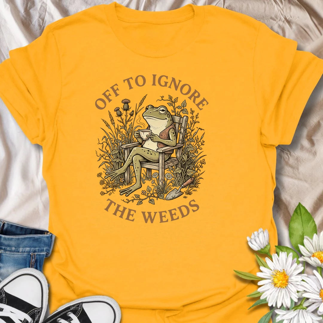 This Off To Ignore The Weeds t-shirt is perfect for gardeners who love the garden but are not always rushing to pull every weed. Featuring a relaxed frog sitting in a garden chair surrounded by plants, flowers, and overgrown greenery, this funny botanical design is great for plant lovers, backyard gardeners, cottage garden fans, frog lovers, and anyone who believes weeds can wait.