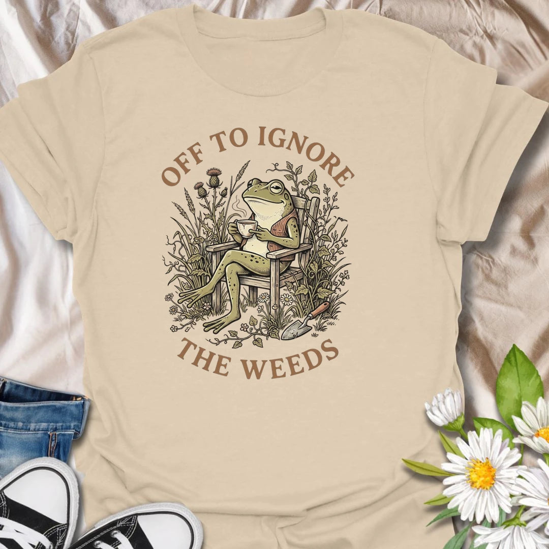 This Off To Ignore The Weeds t-shirt is perfect for gardeners who love the garden but are not always rushing to pull every weed. Featuring a relaxed frog sitting in a garden chair surrounded by plants, flowers, and overgrown greenery, this funny botanical design is great for plant lovers, backyard gardeners, cottage garden fans, frog lovers, and anyone who believes weeds can wait.
