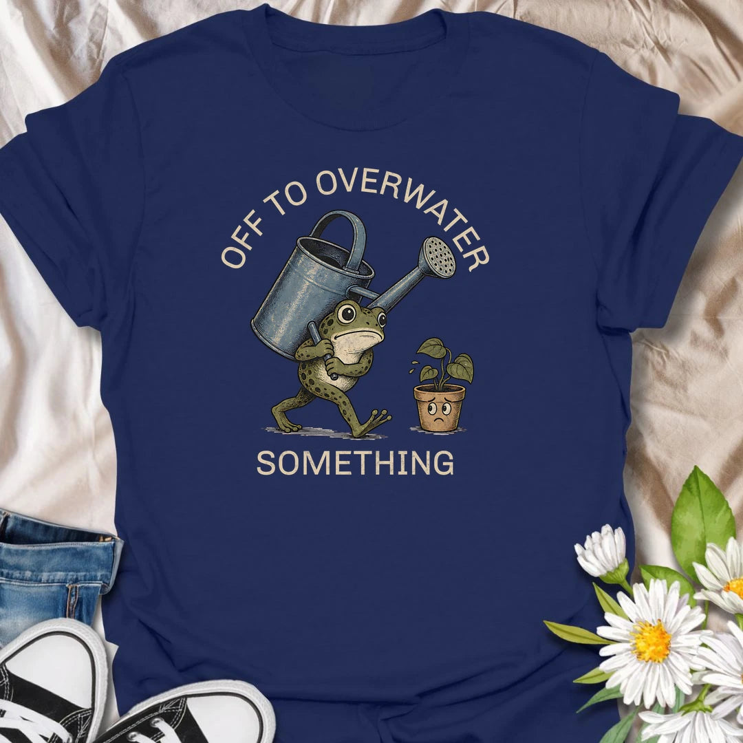 This Off To Overwater Something t-shirt is perfect for plant lovers who know their watering can is both a tool and a potential threat. Featuring a determined frog carrying a big watering can toward a worried potted plant, this funny houseplant design is great for plant moms, plant dads, beginner plant parents, indoor gardeners, and anyone who loves their plants a little too enthusiastically.