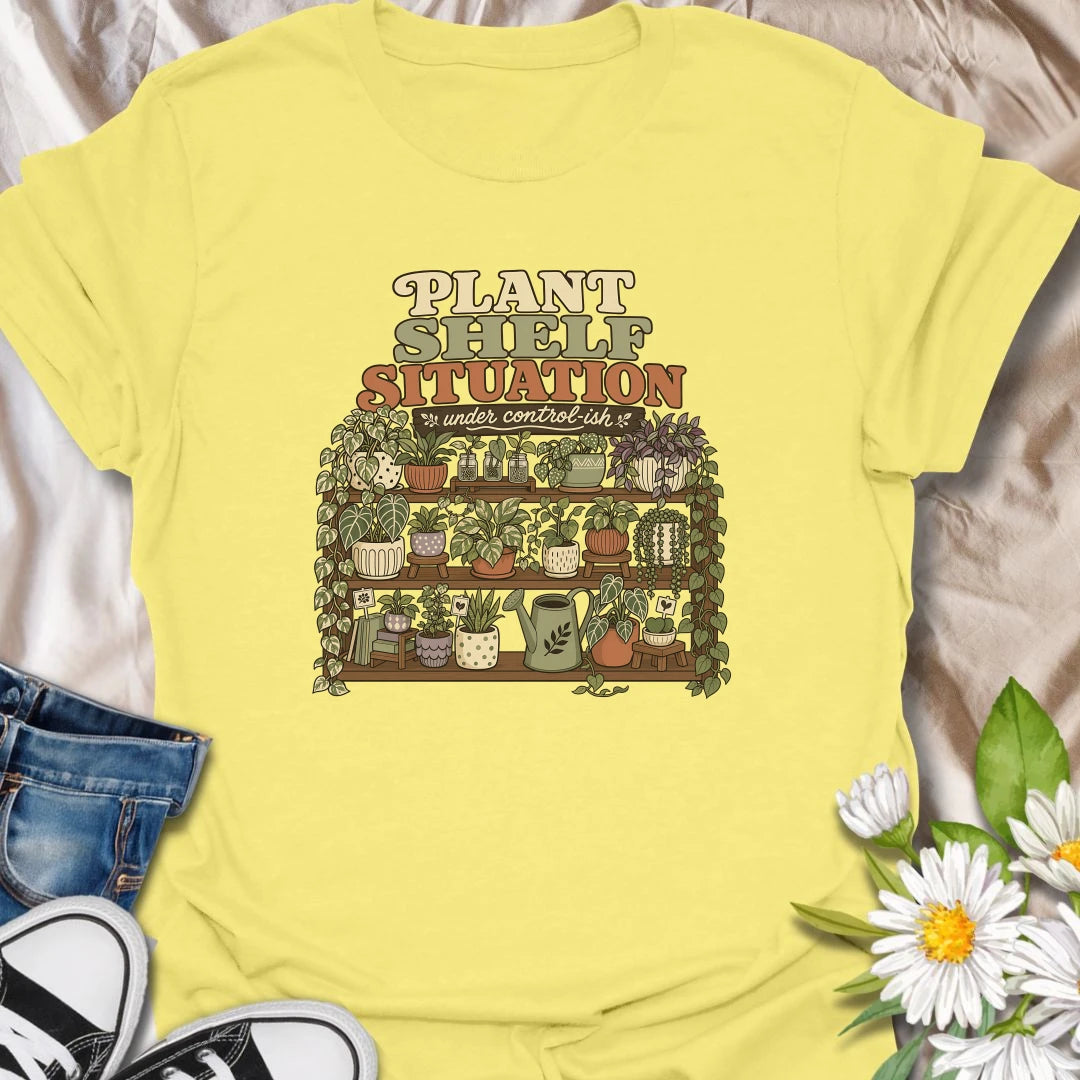 Celebrate a gloriously crowded indoor jungle with this funny “Plant Shelf Situation” T-shirt. Featuring shelves packed with trailing houseplants, decorative pots, propagation jars, and a watering can, it perfectly captures a collection that is only “under control-ish.” A fun gift for plant moms, houseplant collectors, and anyone who always finds room for one more plant.