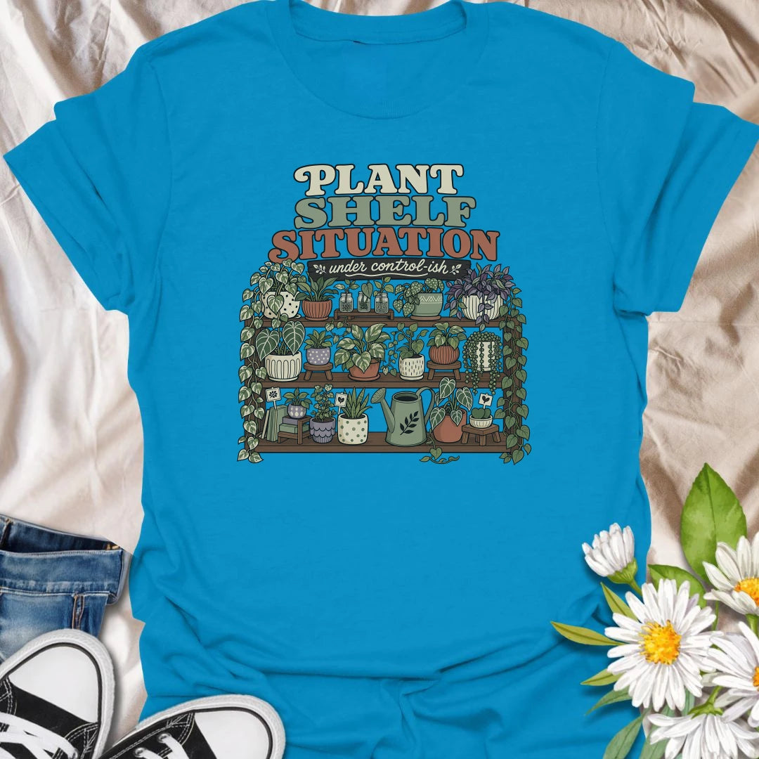 Celebrate a gloriously crowded indoor jungle with this funny “Plant Shelf Situation” T-shirt. Featuring shelves packed with trailing houseplants, decorative pots, propagation jars, and a watering can, it perfectly captures a collection that is only “under control-ish.” A fun gift for plant moms, houseplant collectors, and anyone who always finds room for one more plant.
