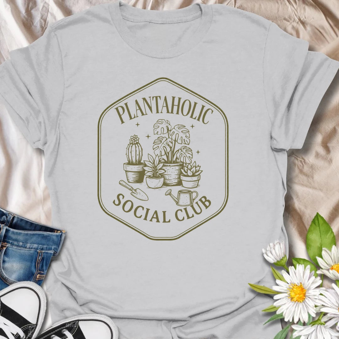 Plantaholic Social Club t-shirt for houseplant collectors who proudly admit the plant obsession is real.
The badge-style design with potted plants, tools, and vintage lettering gives it a fun club-member feel.
It is perfect for plant moms, indoor gardeners, and anyone whose social life includes checking new leaves.
A great gift for plant lovers who belong in a club made entirely of leafy friends and fellow plant addicts.