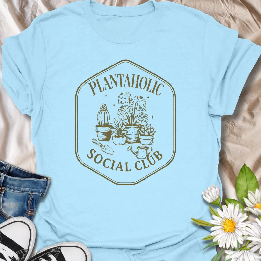 Plantaholic Social Club t-shirt for houseplant collectors who proudly admit the plant obsession is real.
The badge-style design with potted plants, tools, and vintage lettering gives it a fun club-member feel.
It is perfect for plant moms, indoor gardeners, and anyone whose social life includes checking new leaves.
A great gift for plant lovers who belong in a club made entirely of leafy friends and fellow plant addicts.