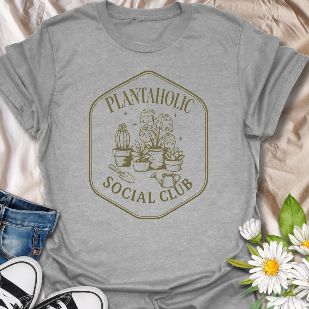 Plantaholic Social Club t-shirt for houseplant collectors who proudly admit the plant obsession is real.
The badge-style design with potted plants, tools, and vintage lettering gives it a fun club-member feel.
It is perfect for plant moms, indoor gardeners, and anyone whose social life includes checking new leaves.
A great gift for plant lovers who belong in a club made entirely of leafy friends and fellow plant addicts.