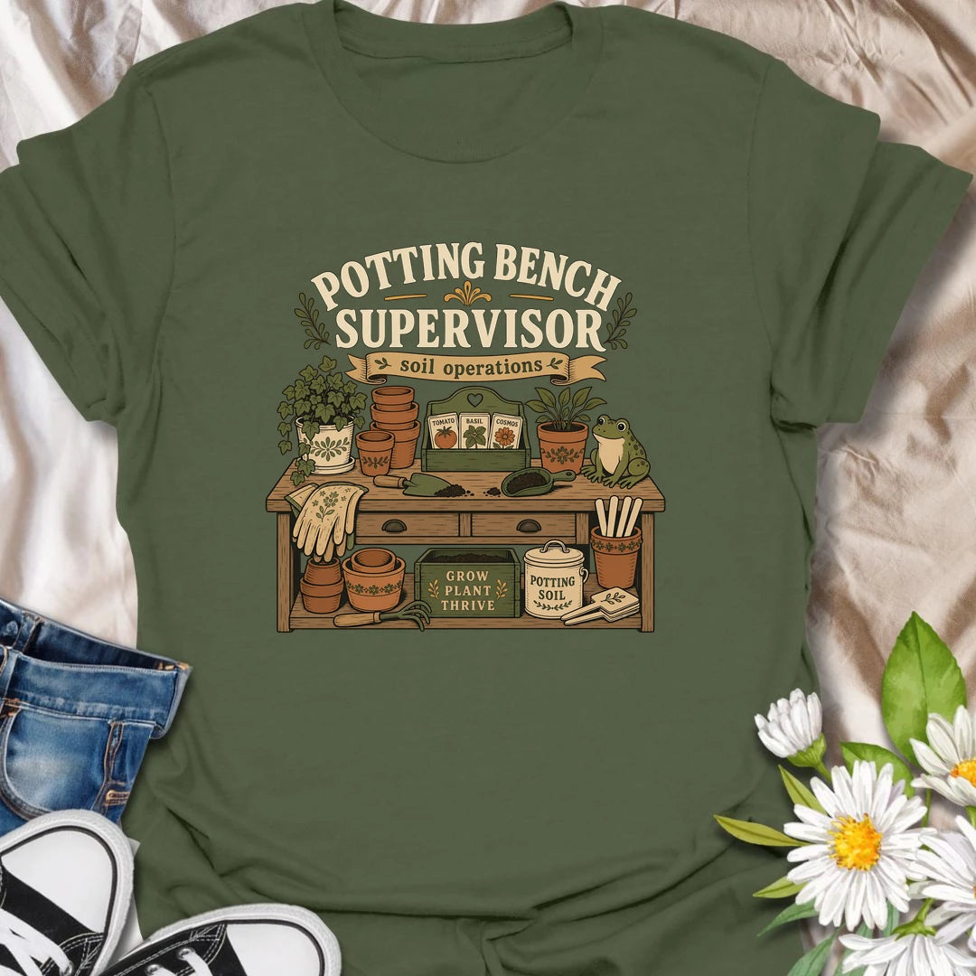 A vintage gardening T-shirt for anyone who considers the potting bench their personal headquarters. The detailed design features seed packets, terracotta pots, soil scoops, garden gloves, and a watchful frog supervisor. A fun gift for gardeners, seed starters, potting enthusiasts, and backyard growers.