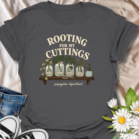 Cheer on every new root with this “Rooting for My Cuttings” T-shirt. The propagation-themed design features pothos, monstera, philodendron, and herb cuttings growing in glass jars. It is a thoughtful and funny gift for houseplant lovers who are always starting another plant baby.