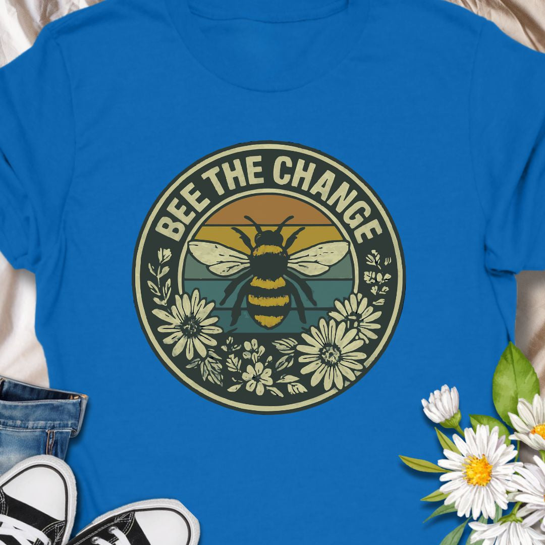 Spread positivity and environmental awareness with this vintage-style “Bee The Change” t-shirt. Featuring a bold bee illustration surrounded by wildflowers and retro sunset colors, it’s perfect for nature lovers, pollinator protectors, and eco-conscious souls. Makes a thoughtful gift for beekeepers, gardeners, or anyone who believes in making a difference—one bee at a time.