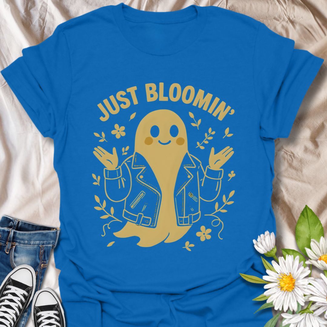 Cute ghost wearing a leather jacket surrounded by blooming flowers with the phrase "Just Bloomin'." A playful and trendy floral ghost graphic perfect for spooky season lovers, goth garden fans, and alternative aesthetic apparel.
