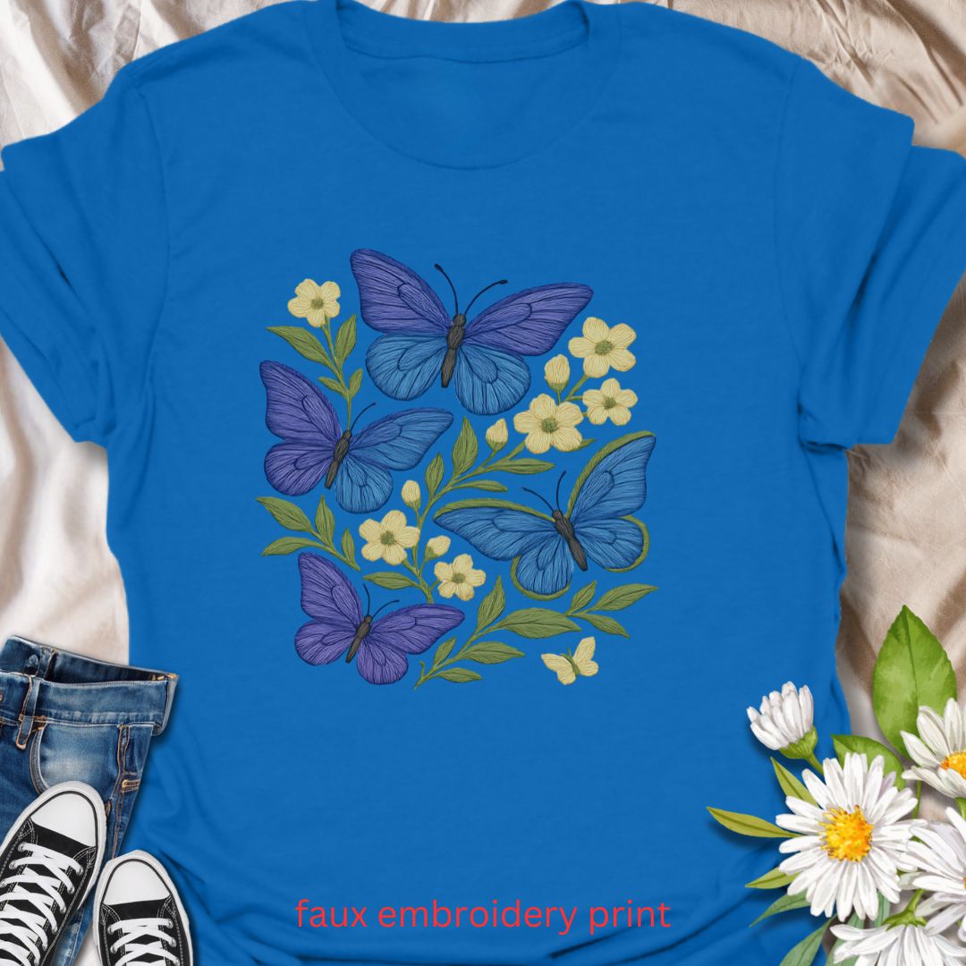 Bring whimsical garden vibes to your wardrobe with this faux embroidery butterfly and floral t-shirt. Featuring vibrant blue and purple butterflies among soft yellow flowers, this nature-inspired design mimics stitched embroidery for a cozy, handmade look—without the thread. Perfect for lovers of cottagecore fashion, pollinator gardens, and floral aesthetics.